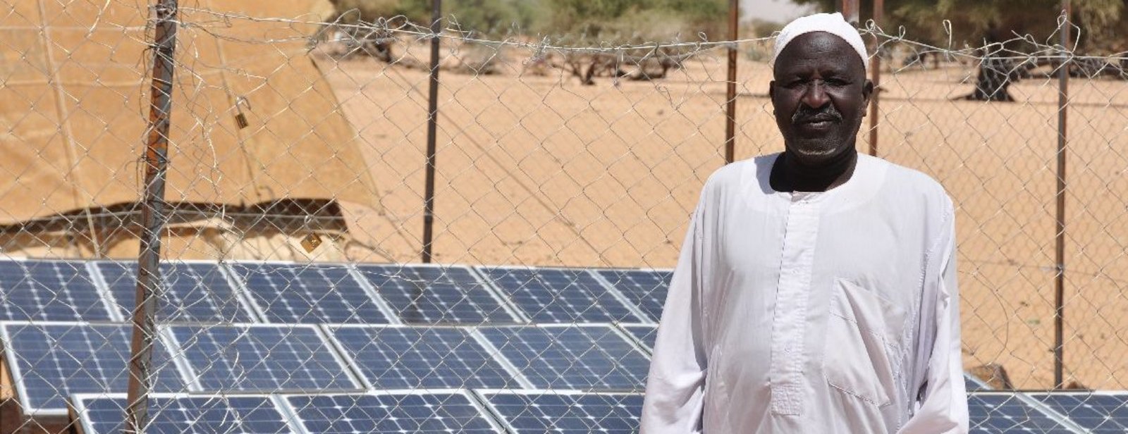 Mann im Tschad vor Solarpanelen
