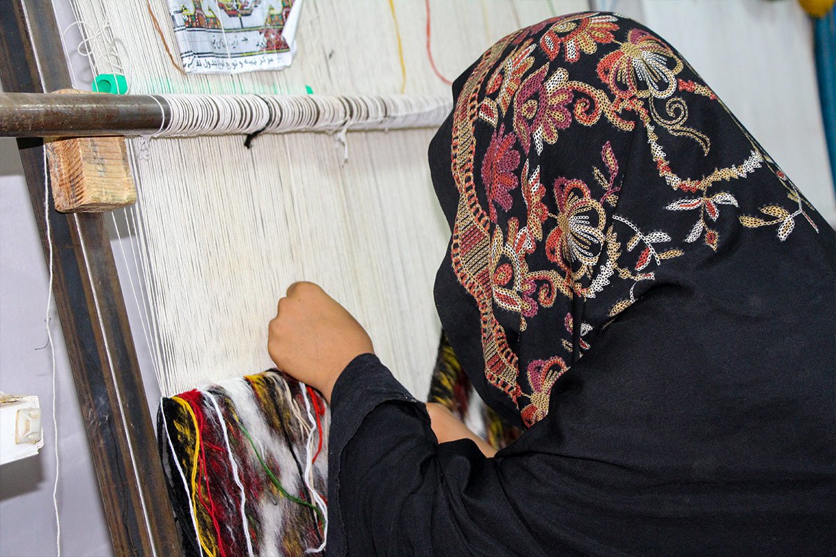 Eine afghanische Weberin bei der Arbeit