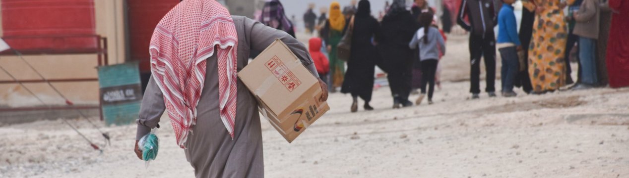 Mann mit Hilfspaket in syrischem Flüchtlingslager