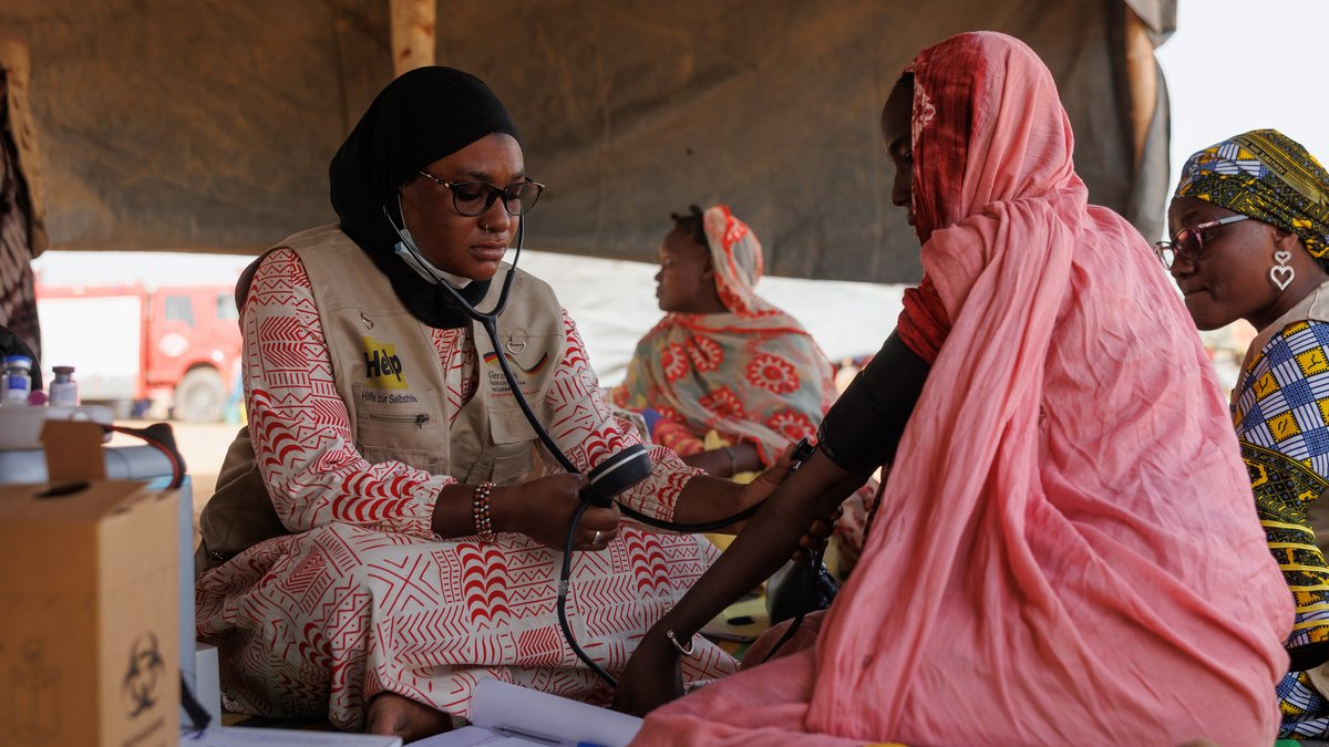 Eine Gesundheitsmitarbeiterin von Help Mali misst den Blutdruck einer Frau