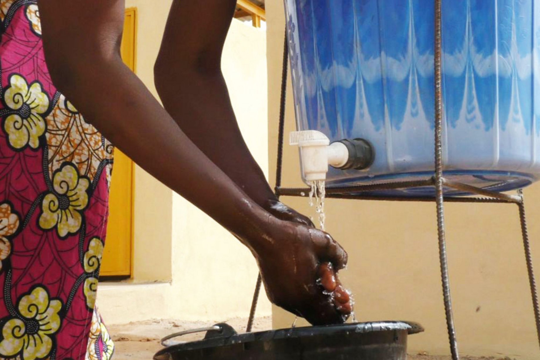 Eine Frau wäscht sich die Hände an einer Handwaschstation