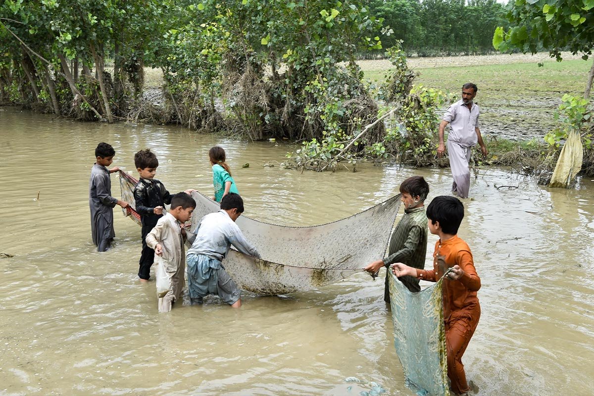 Kinder mit Fischernetz im Fluss