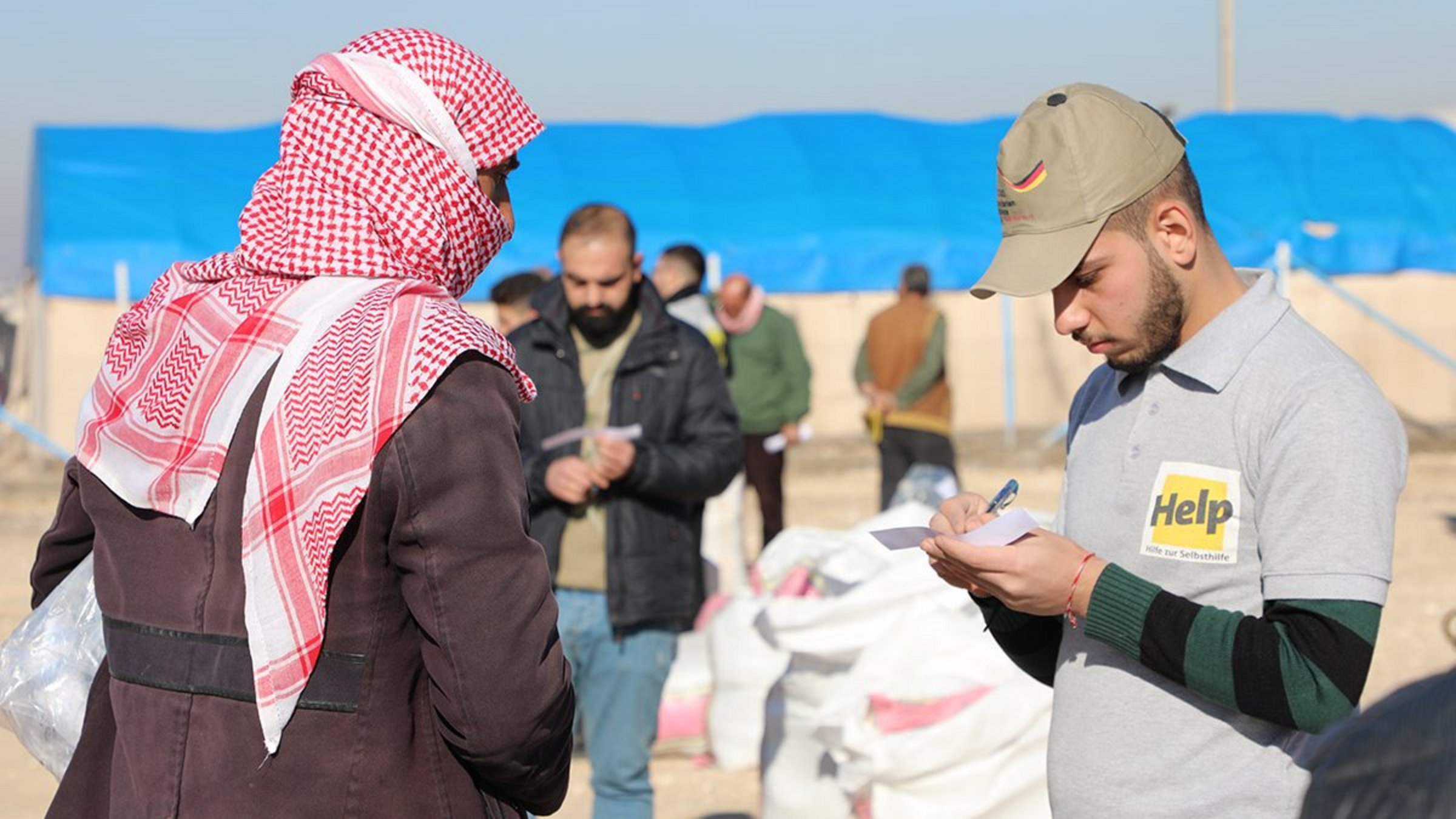 Ein Help-Mitarbeiter im Gespräch mit einem syrischen Mann