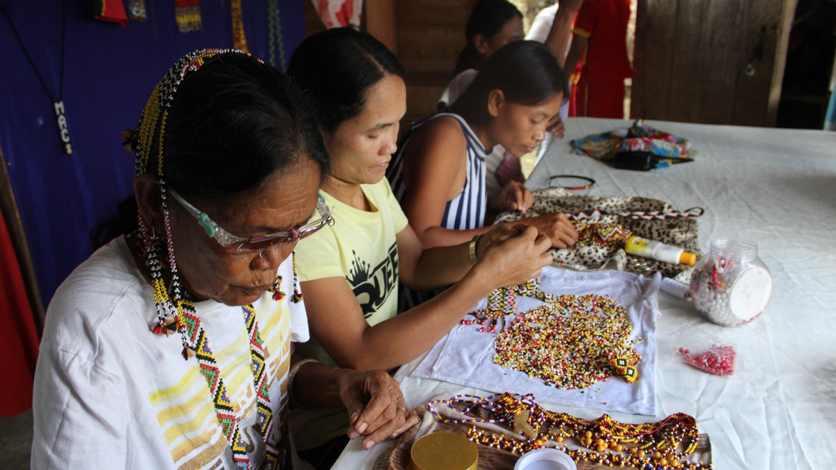 Three women make jewelry