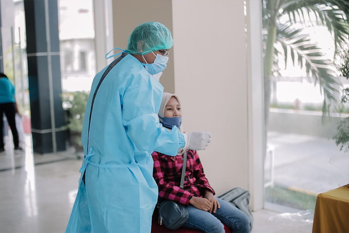 Ein medizinischer Helfer führt einen Corona-Test bei einer Frau in Indonesien durch