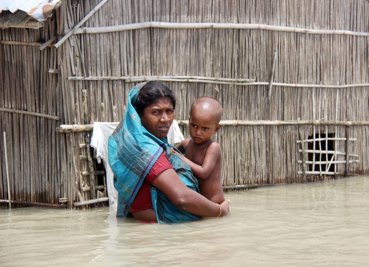Mutter mit ihrem Kind aus Bangladesch stehen hüfthoch im Wasser