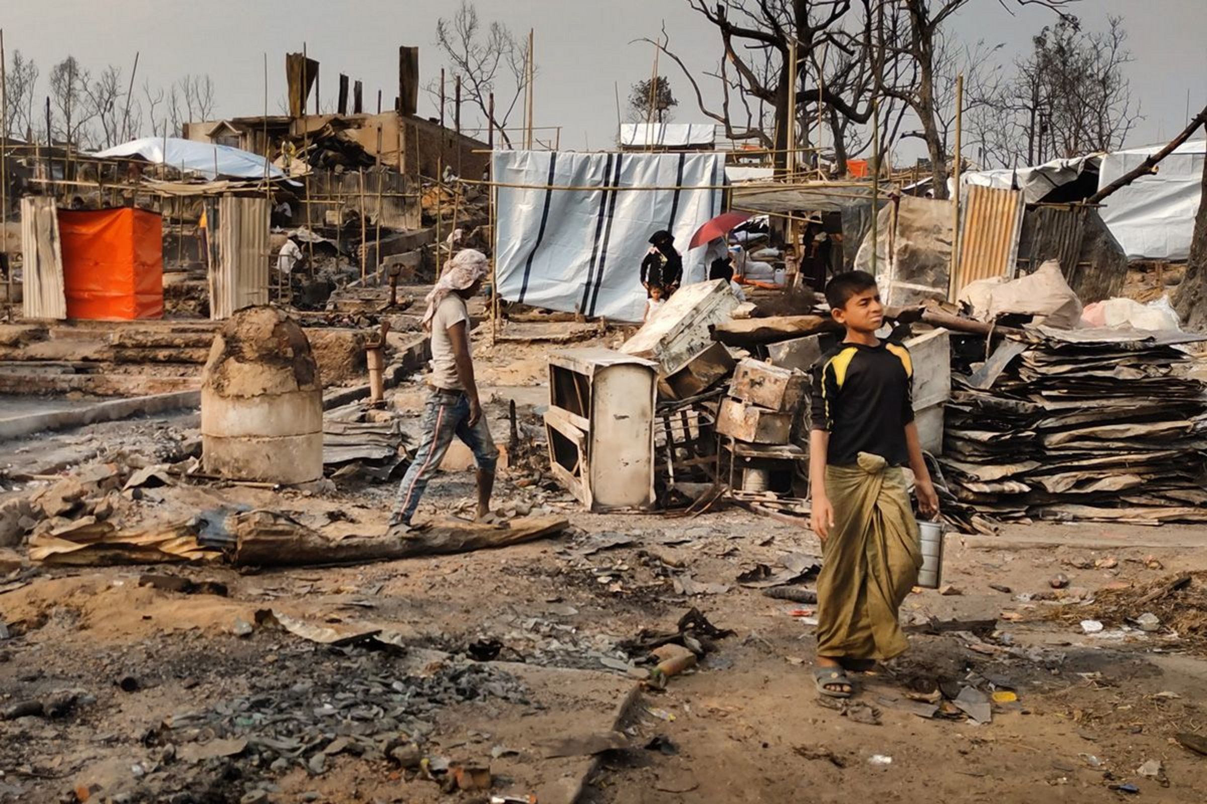 Ein Kind steht in den Überresten des verbrannten Flüchtlingslagers Kutupalong-Balukhali in Bangladesch