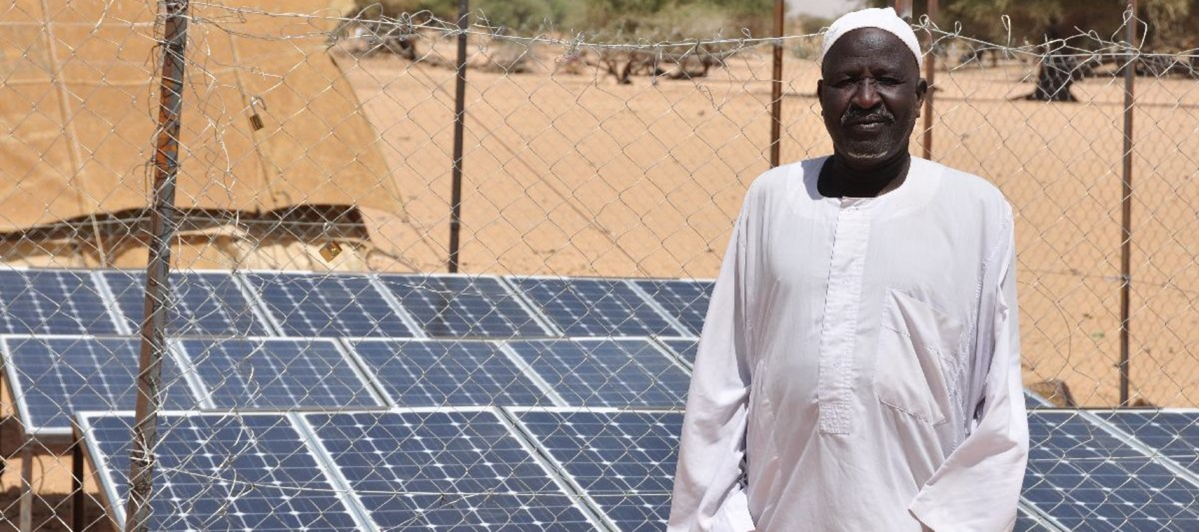 Mann im Tschad vor Solarpanelen
