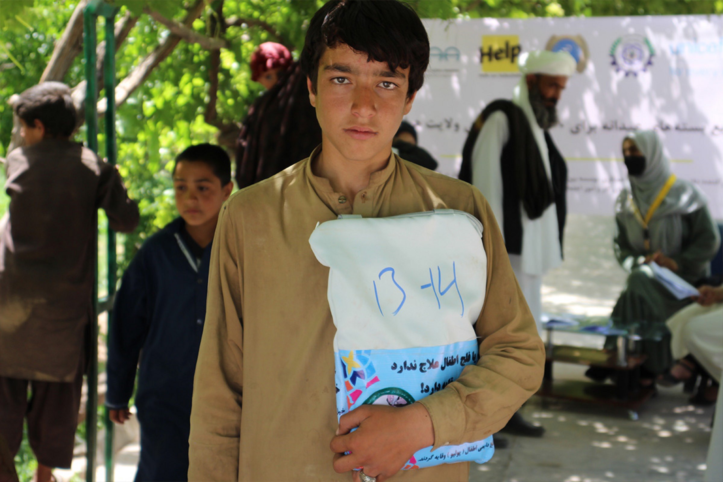 Ein afghanischer Junge erhält Kleidung von Help