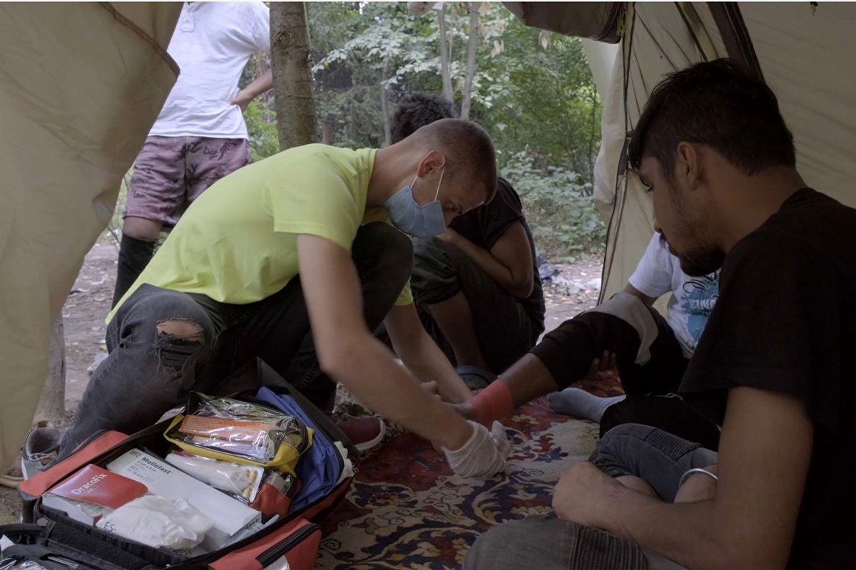 Ein Mitarbeiter unserer Partnerorganisation behandelt einen Geflüchteten an der bosnischen Grenze.