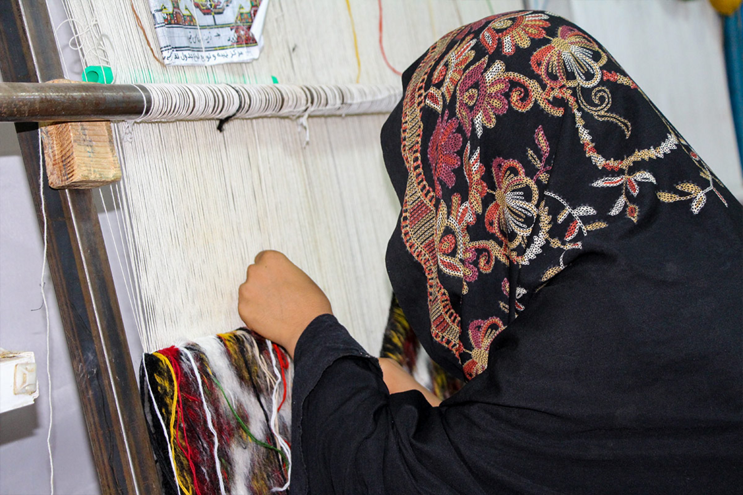 Eine afghanische Weberin bei der Arbeit
