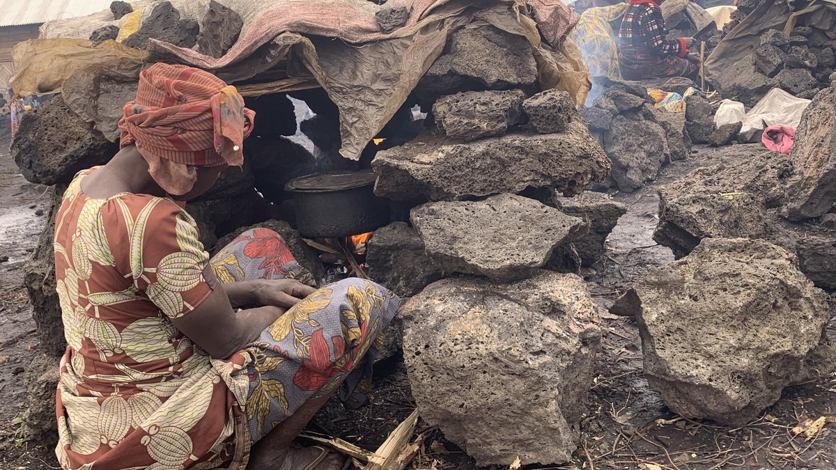 A woman prepares a hot meal in a Congolese refugee camp.