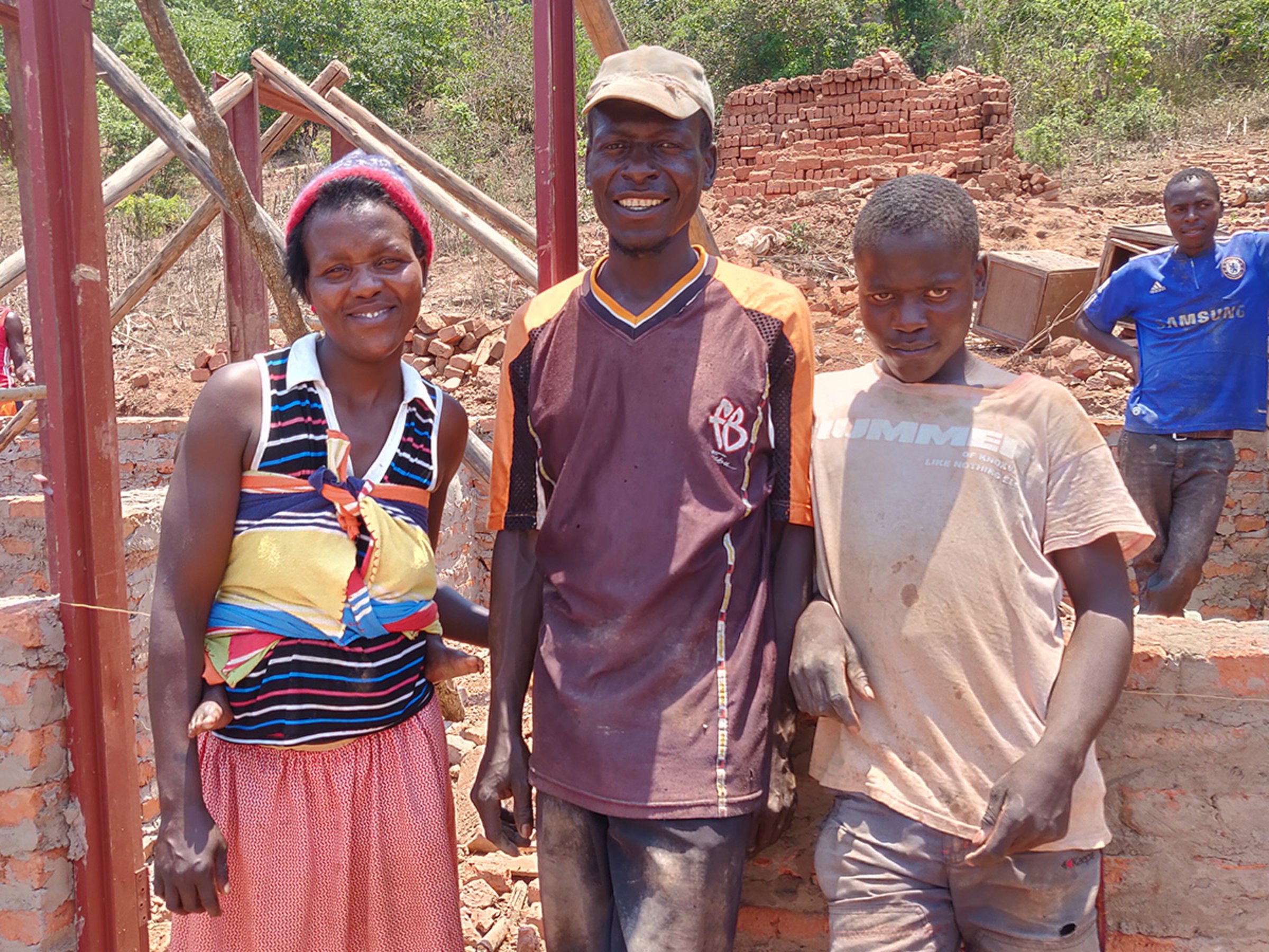 Familie in Simbabwe vorm Rohbau ihres neuen Hauses 
