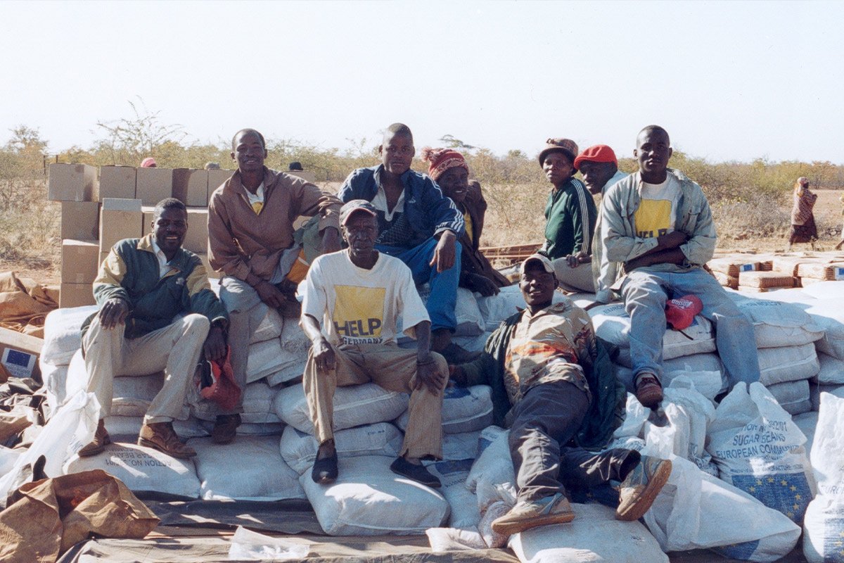 Eine Gruppe Helfer sitzt auf Säcken mit Getreide