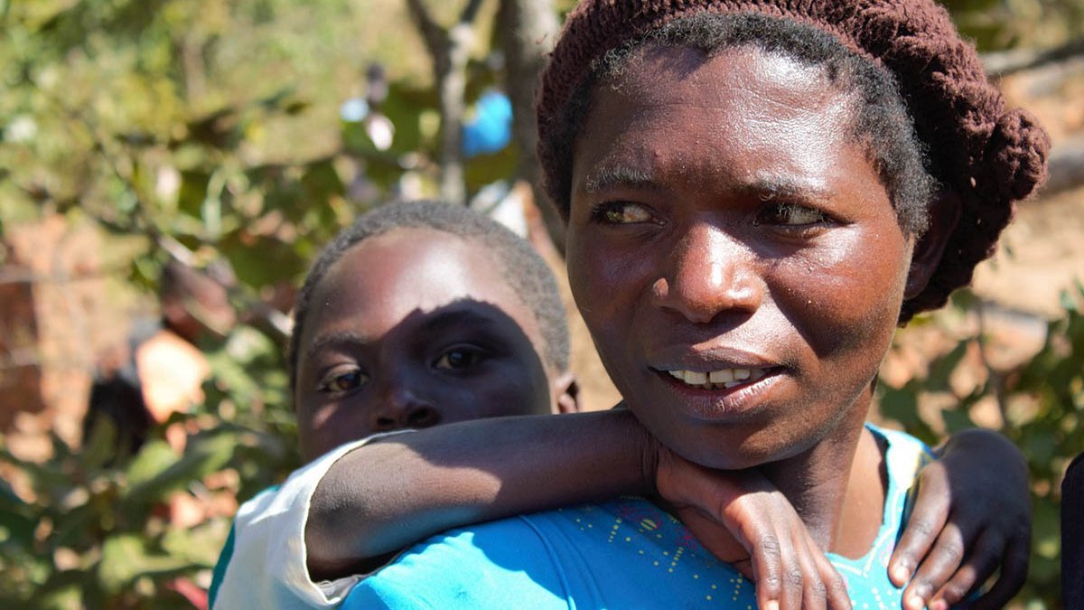 Eine junge Frau in Malawi mit ihrem Kind auf dem Rücken