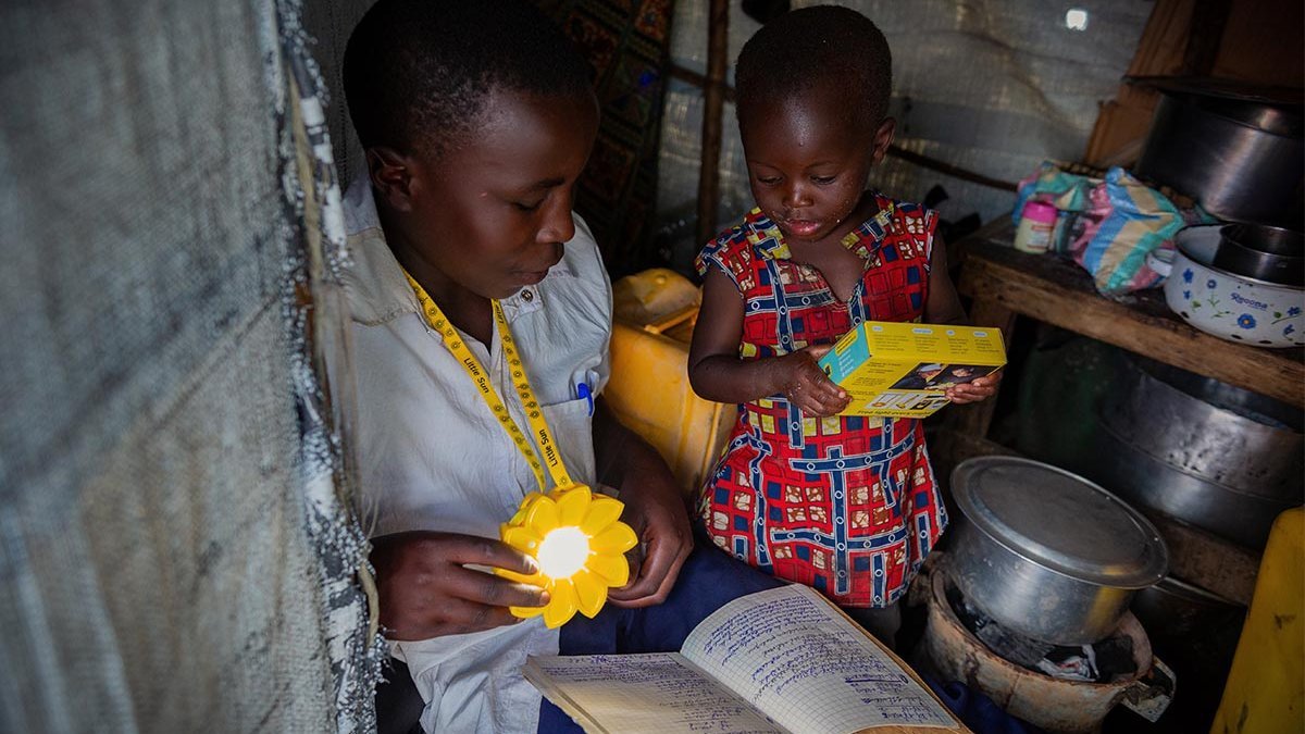 Ein Junge kann dank der Solarlampe auch abends seine Hausaufgaben machen