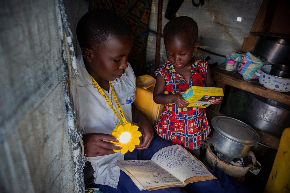 Ein Junge kann dank der Solarlampe auch abends seine Hausaufgaben machen