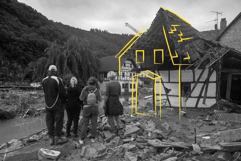 Eine Familie steht vor einem zerstörten Haus in Ahrweiler.