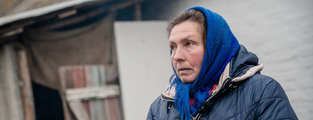 Ukrainische Frau vor ihrem Haus