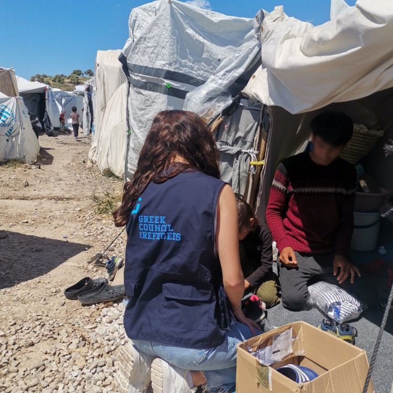Eine humanitäre Helferin spricht mit einem jungen Geflüchteten in Griechenland
