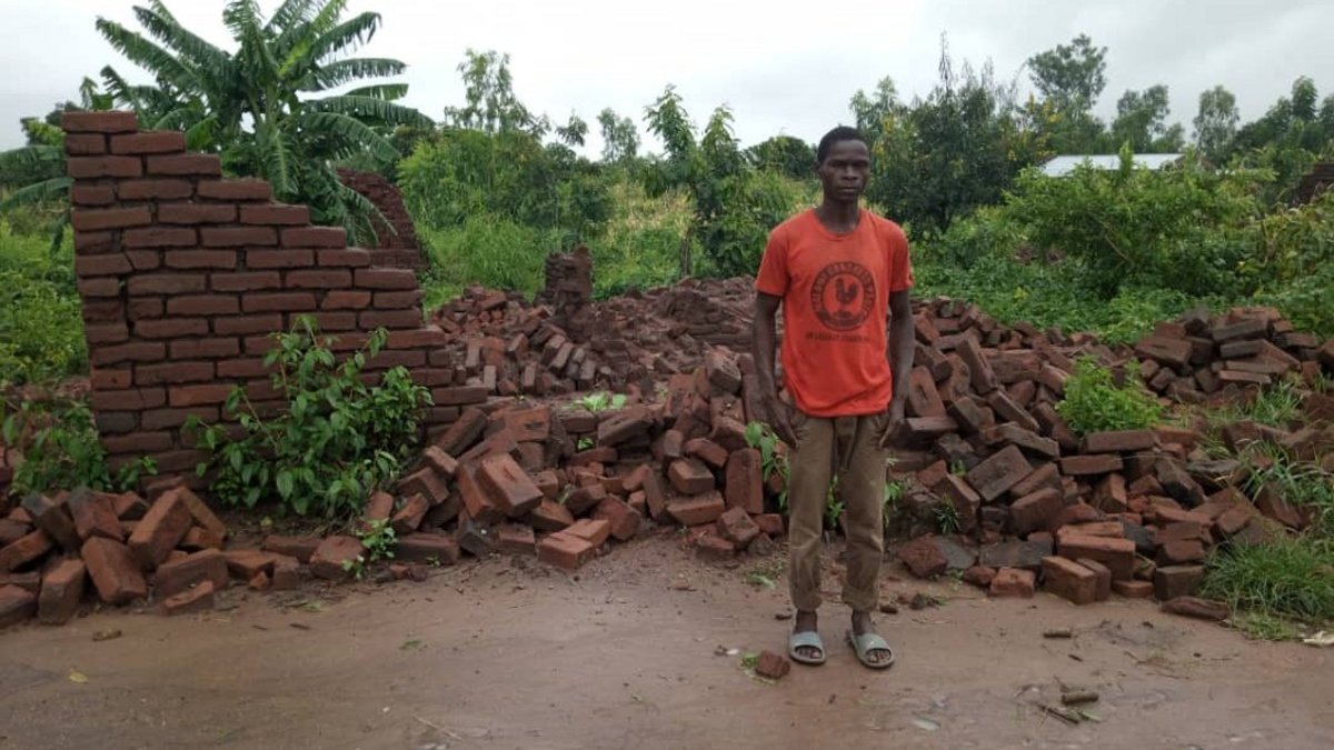 Ein Mann in Malawi vor seinem zerstörten Haus.