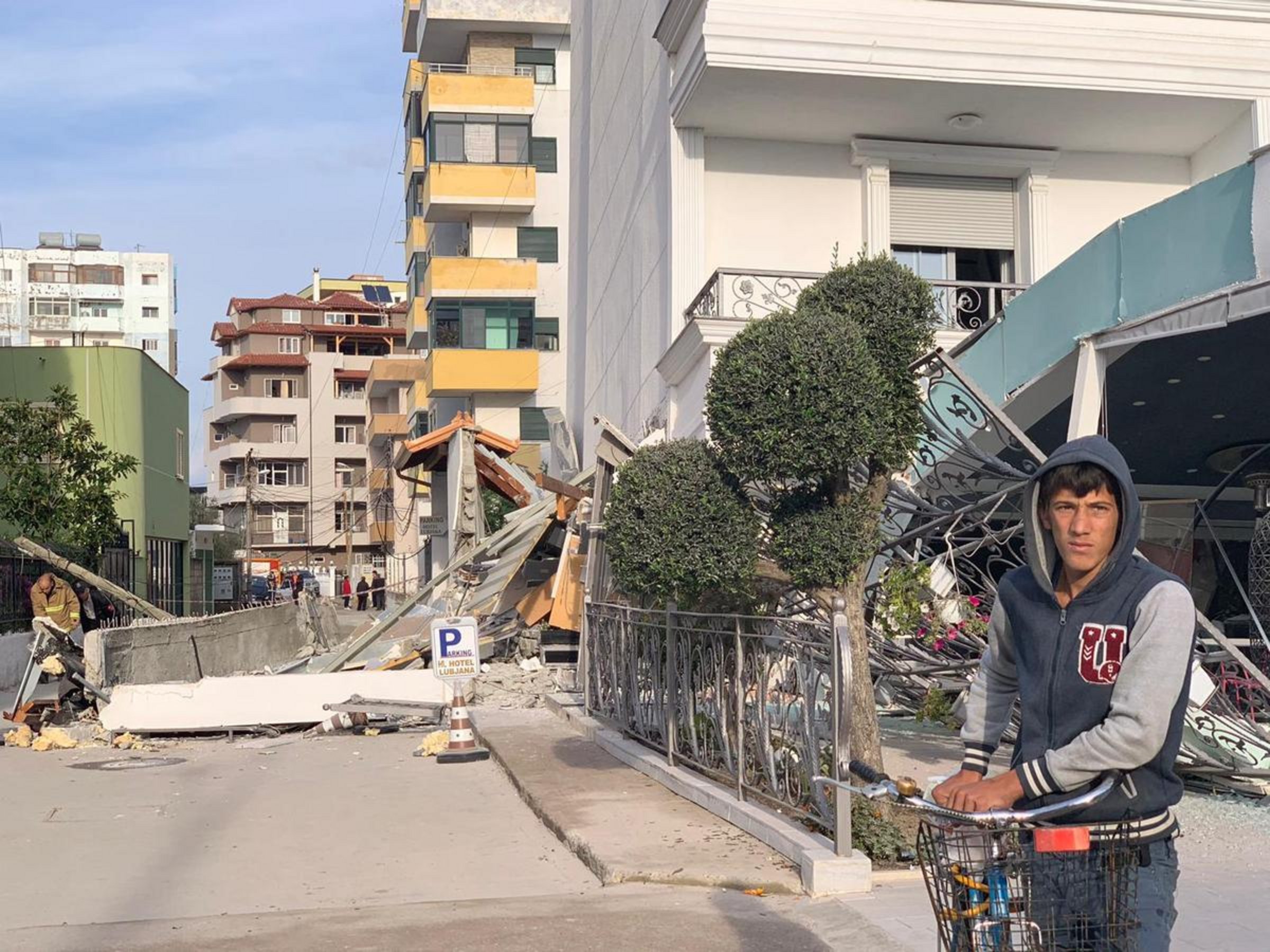 Junger Mann vor zerstörtem Gebäude nach Erdbeben in Albanien