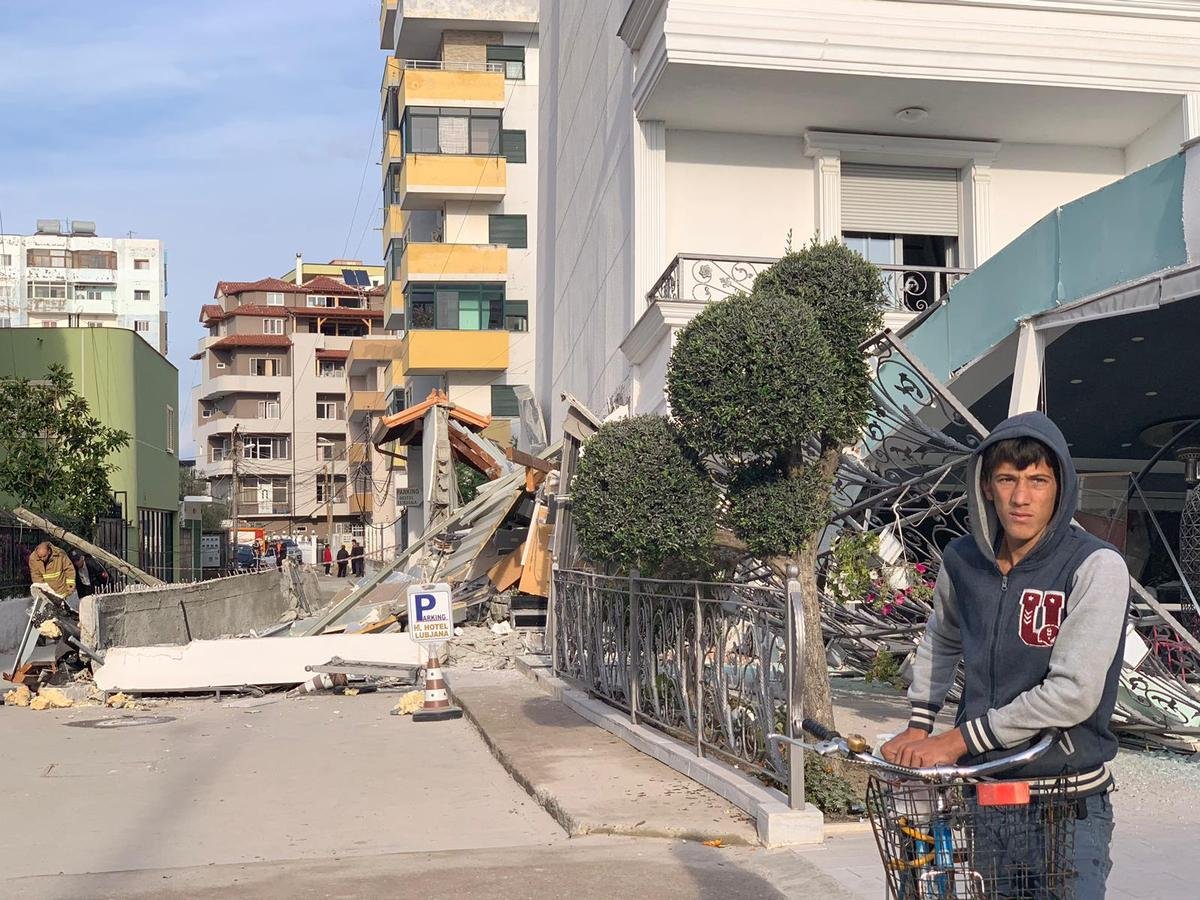 Junger Mann vor zerstörtem Gebäude nach Erdbeben in Albanien