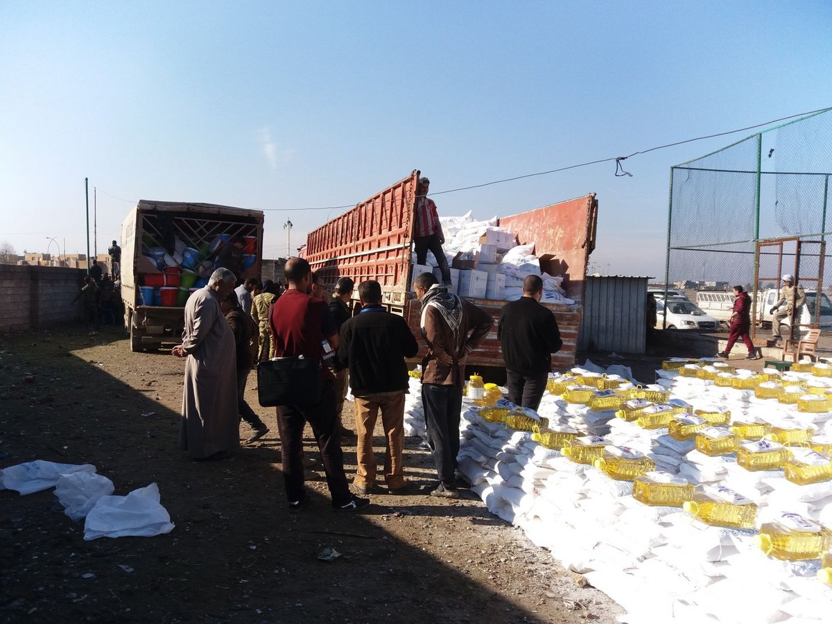 Nahrungsmittelausgave vor einem Flüchtlingslager in Qayyara