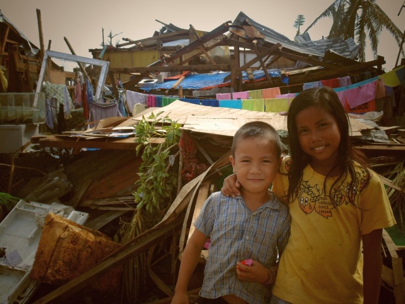 Kinder vor zerstörten Häusern nach Taifun Mangkhut auf den Philippinen 