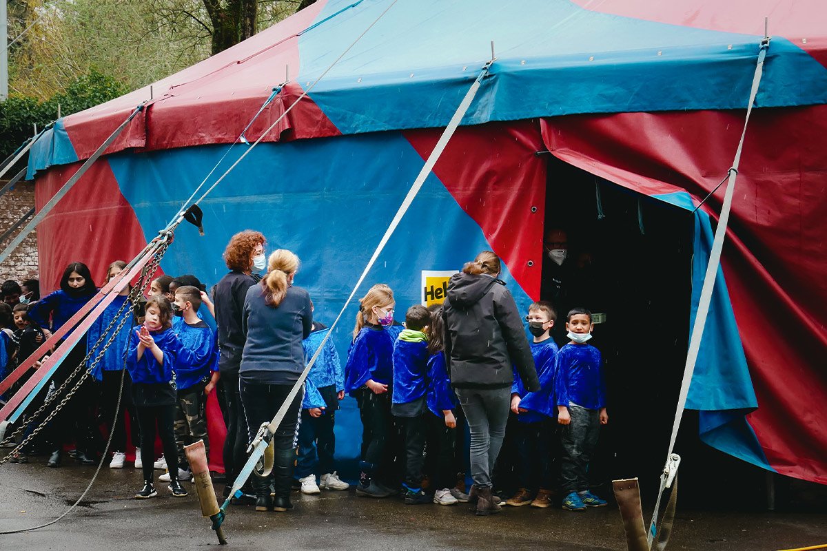 Kinder stehen vor einem Zirkuszelt