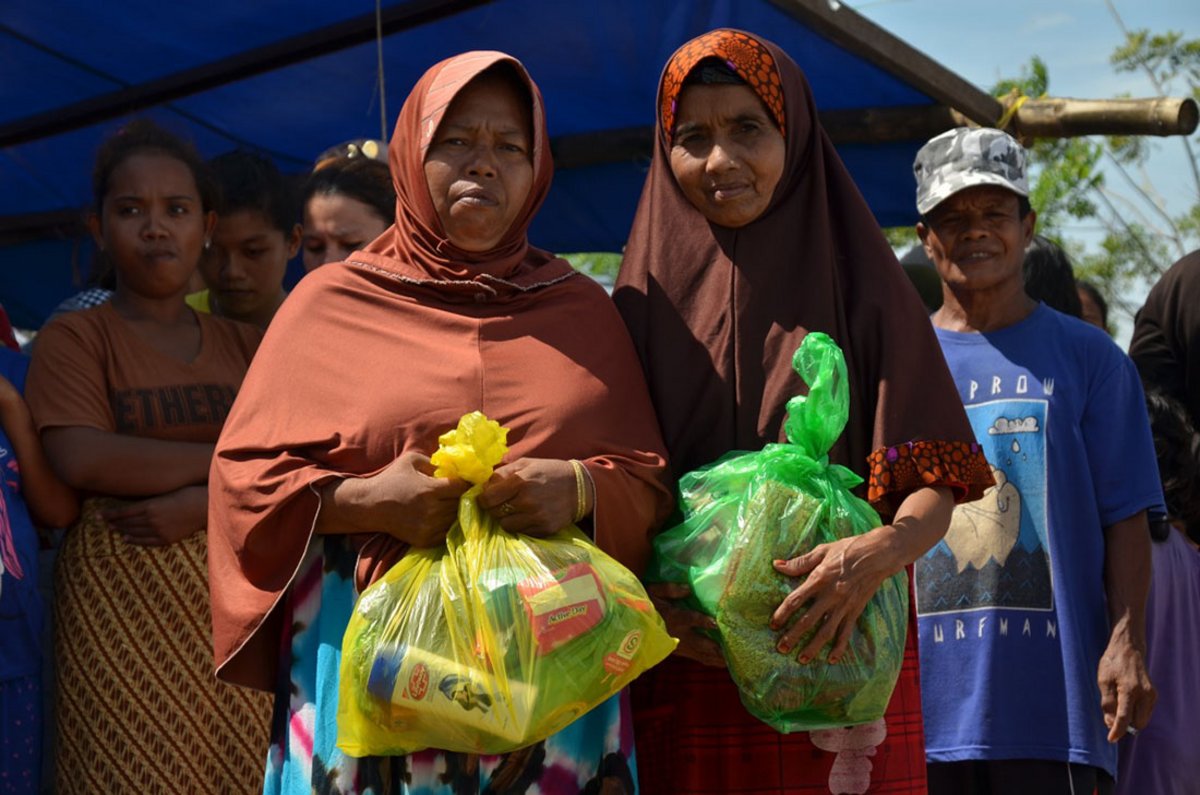 Zwei Frauen in Indonesien halten Hilfsgüter von Help in den Händen