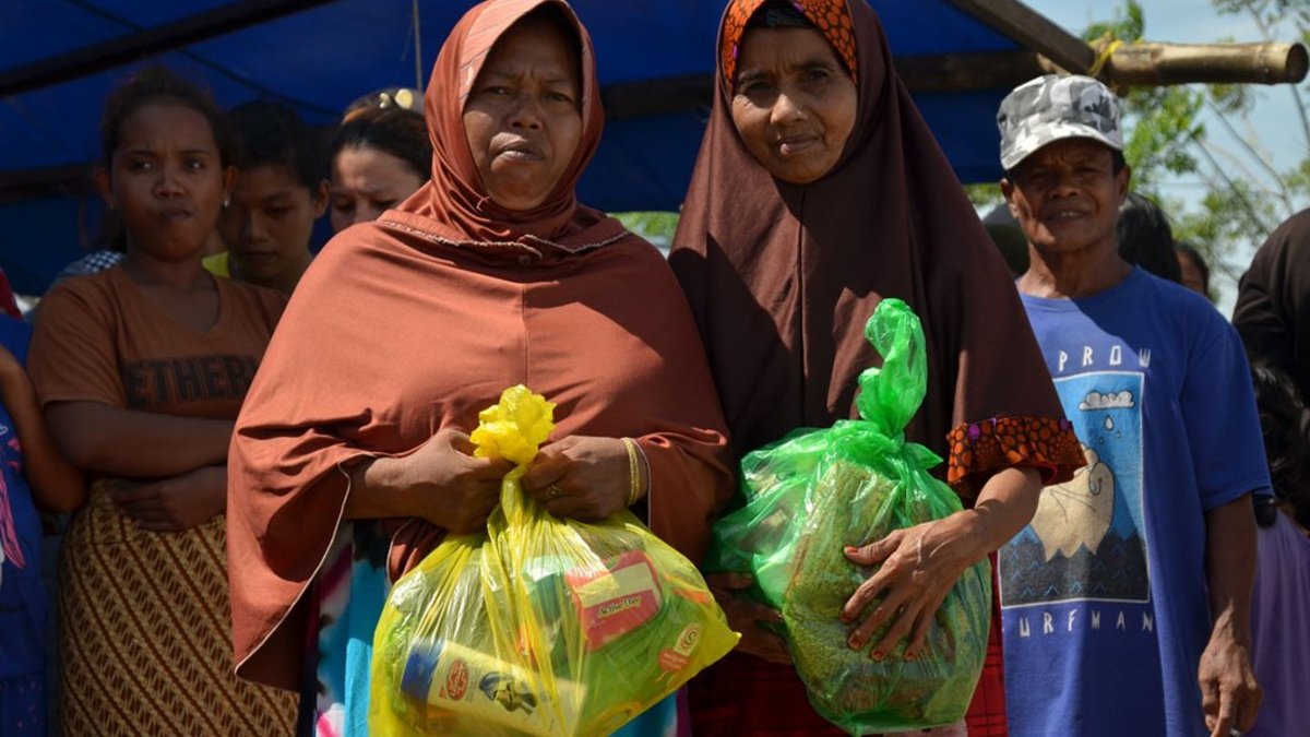 Zwei Frauen in Indonesien halten Hilfsgüter von Help in den Händen