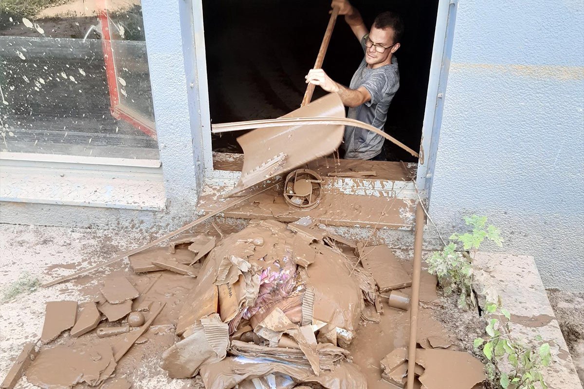 Ein Mann schippt Schlamm aus dem Keller des Jugendhilfezentrums Don Bosco in Welschbillig