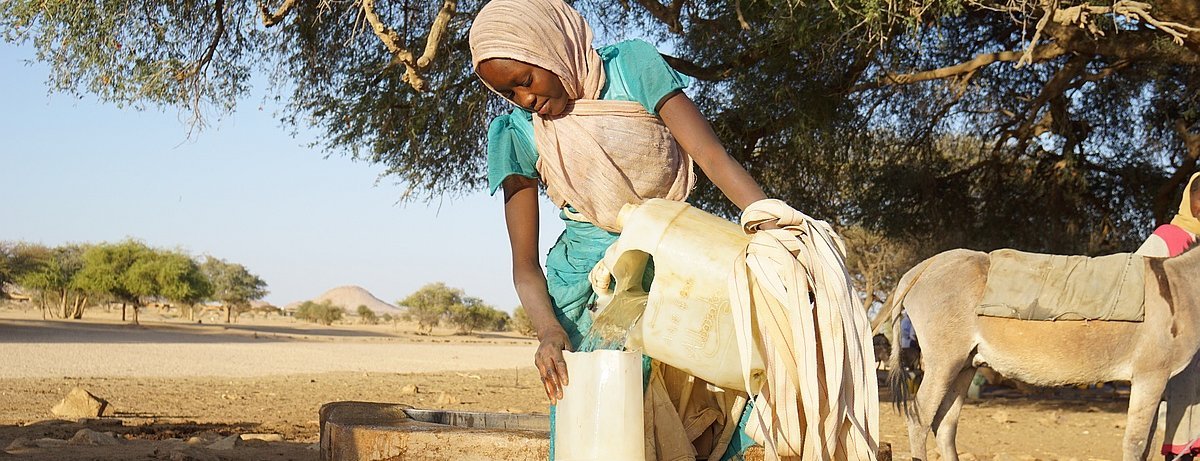 Frau im Tschad füllt Wasserkanister