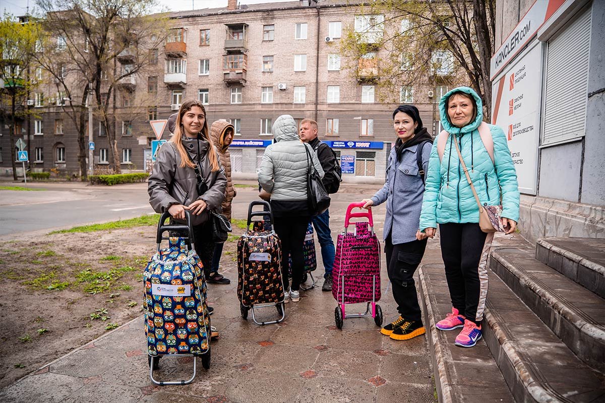 Ukrainische Frauen mit ihren Hilfspakete-Wagen von Help
