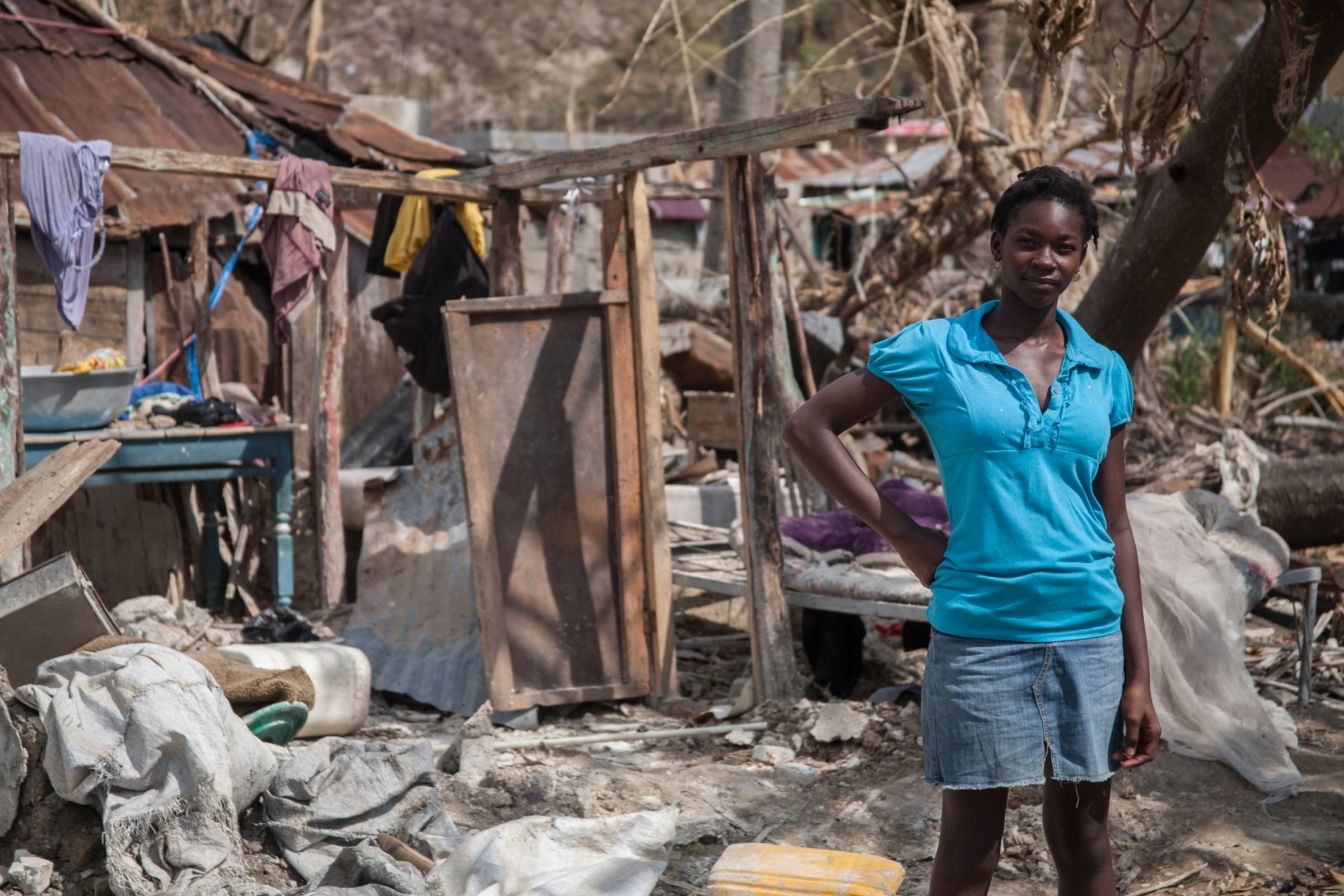 Eine Haitianerin vor den Trümmern ihres Hauses 