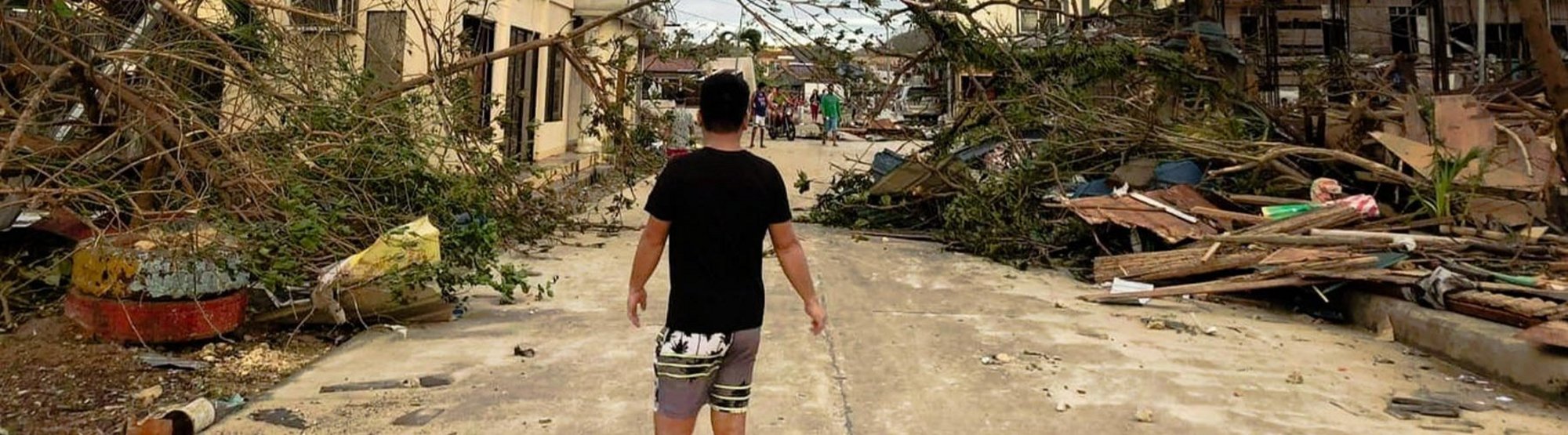 Ein Mann läuft durch eine von Taifun Rai zerstörte Siedlung auf den Philippinen