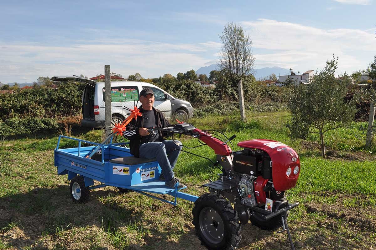 Ein Landwirt in Albanien freut sich über die neue Ausrüstung, die er von Help erhalten hat.