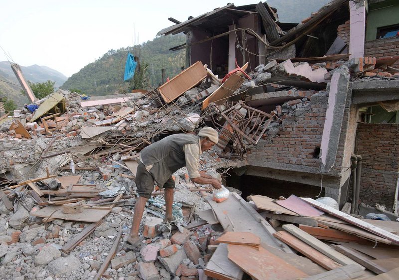 Mann durchsucht Trümmern nach Erdbeben in Nepal 2015