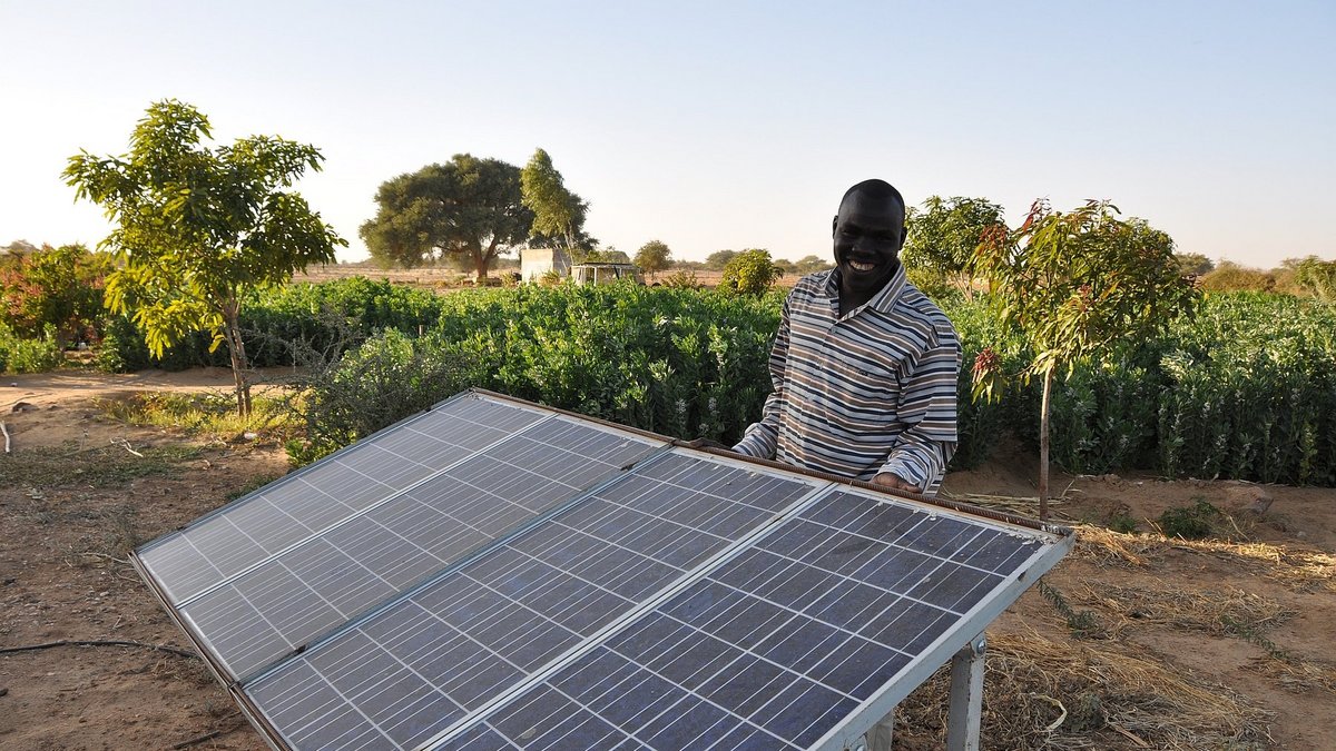 Help Mitarbeiter neben Solarzelle im Tschad