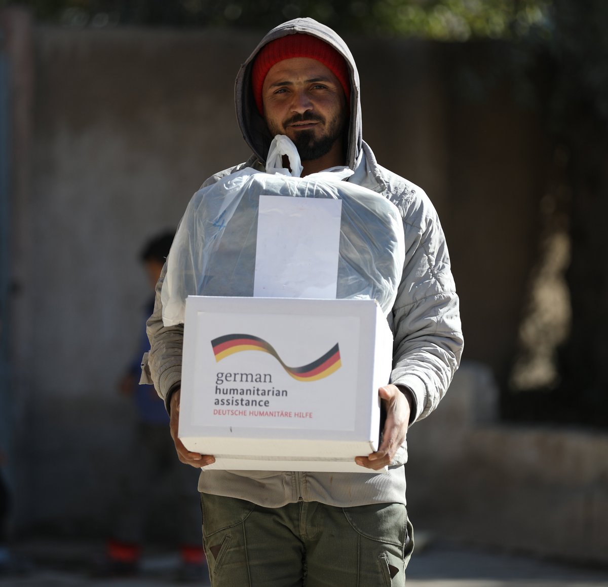 Ein junger Mann in Syrien mit einem Hilfspaket von Help