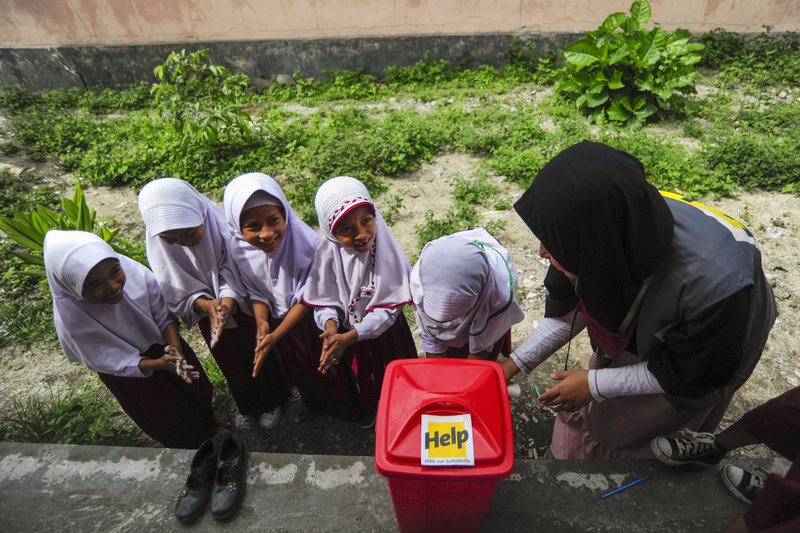 Eine Help-Mitarbeiterin zeigt indonesischen Kindern, wie sie sich mit gründlichem Händewaschen vor Krankheiten schützen können.